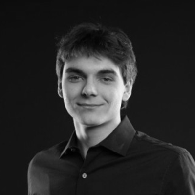 Black and white portrait of a person wearing a dark shirt against a black background